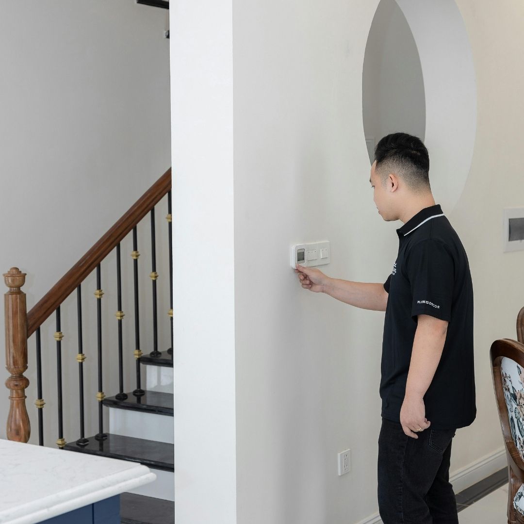 man adjusting thermostat